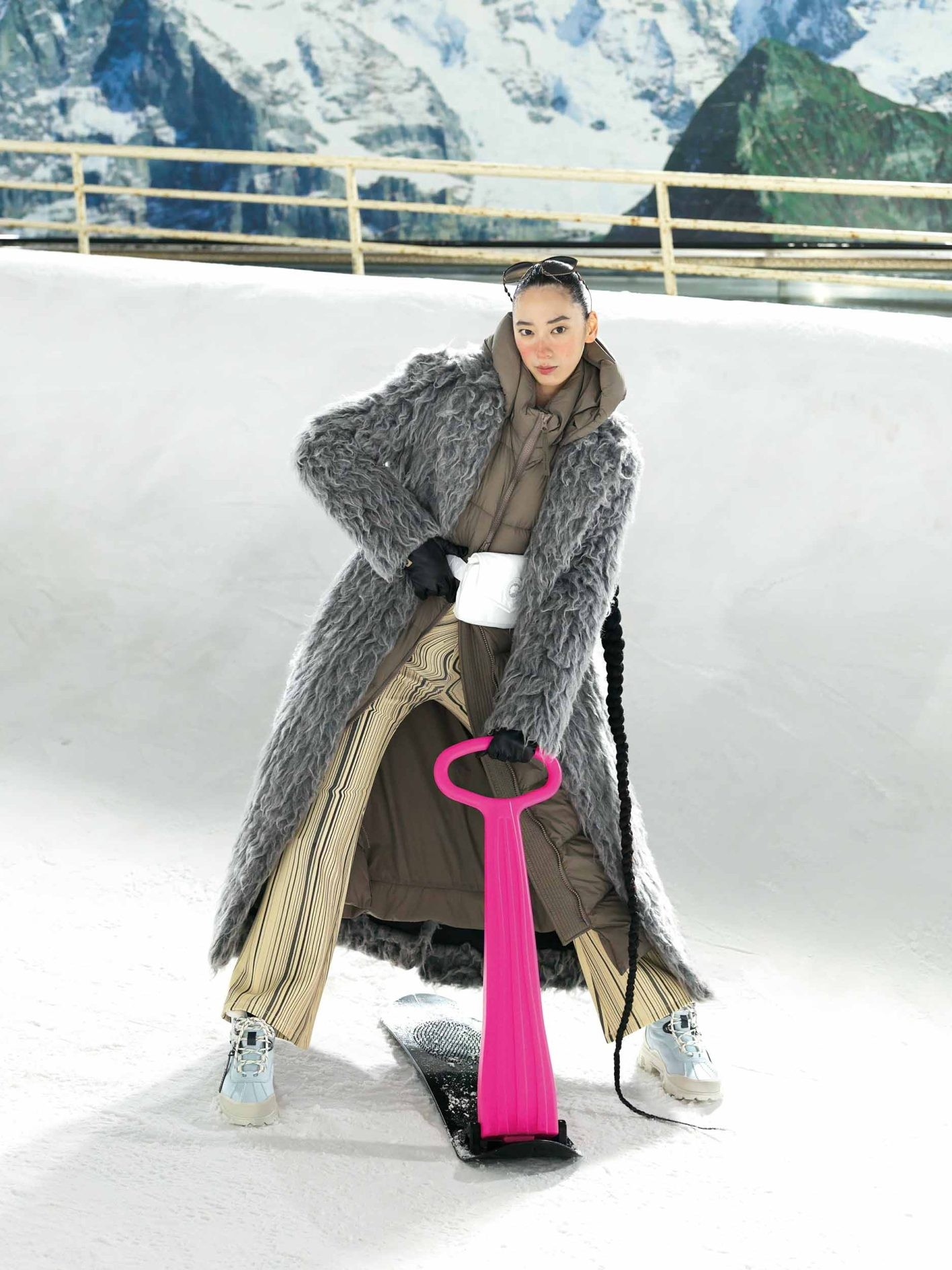 優雅に広がるシャギーコートと、フレアパンツが織りなす華麗なシルエット。リゾートスタイルに映えるロング丈のアウターは、ポーチでウエストマーク。凍った路面での歩行を想定したレザーブーツで、街中も雪山も快適に過ごせる。コート ¥201,300、アイウェア ¥38,940（共にディーゼル | ディーゼル ジャパン）／中に着たダウンコート ¥220,000、ウエストバッグ ¥31,000（共にカナダグース | カナダグースジャパン）／パンツ ¥15,900（デシグアル | デシグアルストア 銀座中央通り店）／グローブ ¥30,800（フミエタナカ | ドール）／スノーシューズ ¥57,200（アグ® | デッカーズ ジャパン）