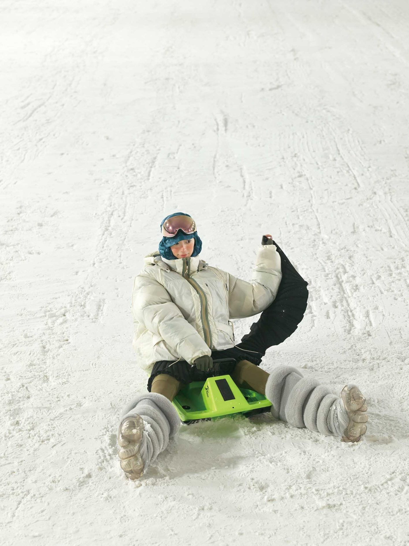 ボリューム満点のアウターとブーツには、ミニ丈をあわせてメリハリを。アシメトリーに裾が垂れたプリーツ状のニットスカートは、雪上で一段と個性を放つ。さらに、ハイキングタイツを重ねれば、アクティビティを思い切り満喫できる着こなしが完成。ダウンジャケット ¥99,000、ゴーグル ¥ 34,430（共にオークリー | ルックスオティカジャパン カスタマーサービス）／スカート ¥35,200（ダブレット | エンケル）／レギンス ¥25,300、バラクラバ ¥11,550（共にピークパフォーマンス | ピークパフォーマンスコールセンター）／グローブ ¥69,3 00（マーモット | サードシップ）／ブーツ＊参考商品（グラウンズ | フールズ）