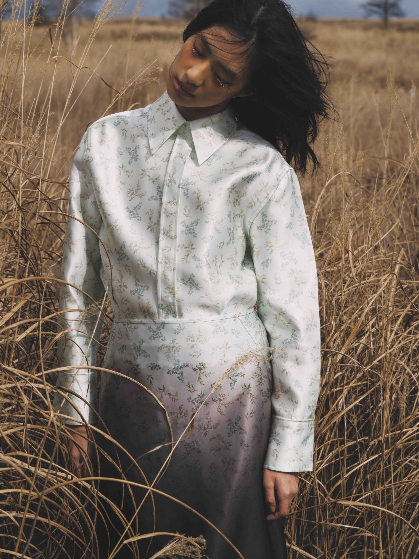 「小花柄が褪せたグラデーションへと美しく流れていく様子が、まるで移り変わる季節のよう」(井伊さん)。闇から光へ、希望に対する願いを込めた〈ジル サンダー〉のコレクション。優雅な光沢のシルク混の生地の上で、漆黒がゆっくりと明るみ、可憐なブーケが浮かび上がる。シャツ ¥404,800、スカート ¥327,800(共にジル サンダー | ジルサンダージャパン)